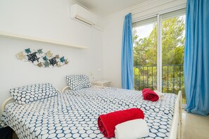 A bedroom with a bed, a nightstand, a wall decoration, and a balcony with curtains. - Casa Pianti Villa in Altea Hills with Sea View, Pools & Wi-Fi (Altea)