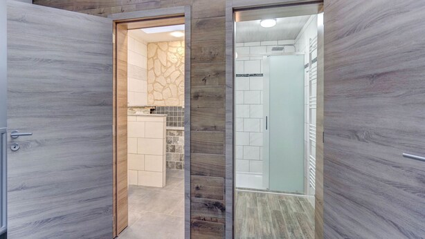 A modern bathroom with a shower, a toilet, and a sink.