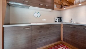 Une cuisine moderne avec des meubles en bois, un lave-vaisselle en acier inoxydable et un plan de travail blanc.