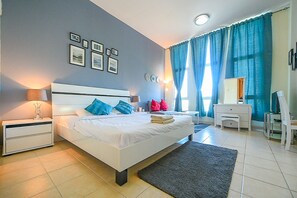 Una camera da letto moderna con un letto grande, comodini, una scrivania e una sedia.