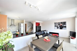 A modern apartment with a kitchen, dining area, and living space. - Beautiful Villa "Es Pas" with Pool, Air Conditioning, Wi-Fi, Terraces & Ocean Views (CALA PI)