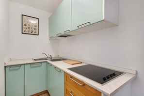 A kitchen with teal cabinets, a white countertop, a sink, and a stove. - Idyllic Apartment 'Innerwalten 200' with Mountain Views, Restaurant & Parking (Walten)