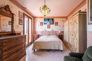 A bedroom with a bed, dresser, wardrobe, and a chandelier. - Villa in the Heart of Chianti — Peace, Views, and Authentic Tuscany (Certaldo - Firenze)