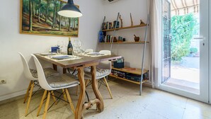 Un comedor con una mesa, sillas y un cuadro en la pared.