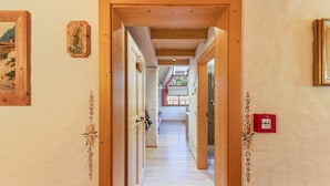 Ein hölzerner Flur mit Decke, einer Tür und einem an der Wand befestigten Lichtschalter.