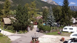 Ein Wohngebiet mit einem Pavillon, Häusern und einer Bergkulisse im Hintergrund.
