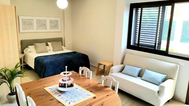 Ein Schlafzimmer mit Bett, Nachttisch und einem Fenster mit Jalousien.