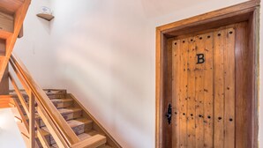 A wooden staircase leading to a door with a letter 'B' on it. - Pet-Friendly Apartment B Armonia Rural with Sea View, Terrace, Shared Pool & Wi-Fi (Granadilla de Abona)