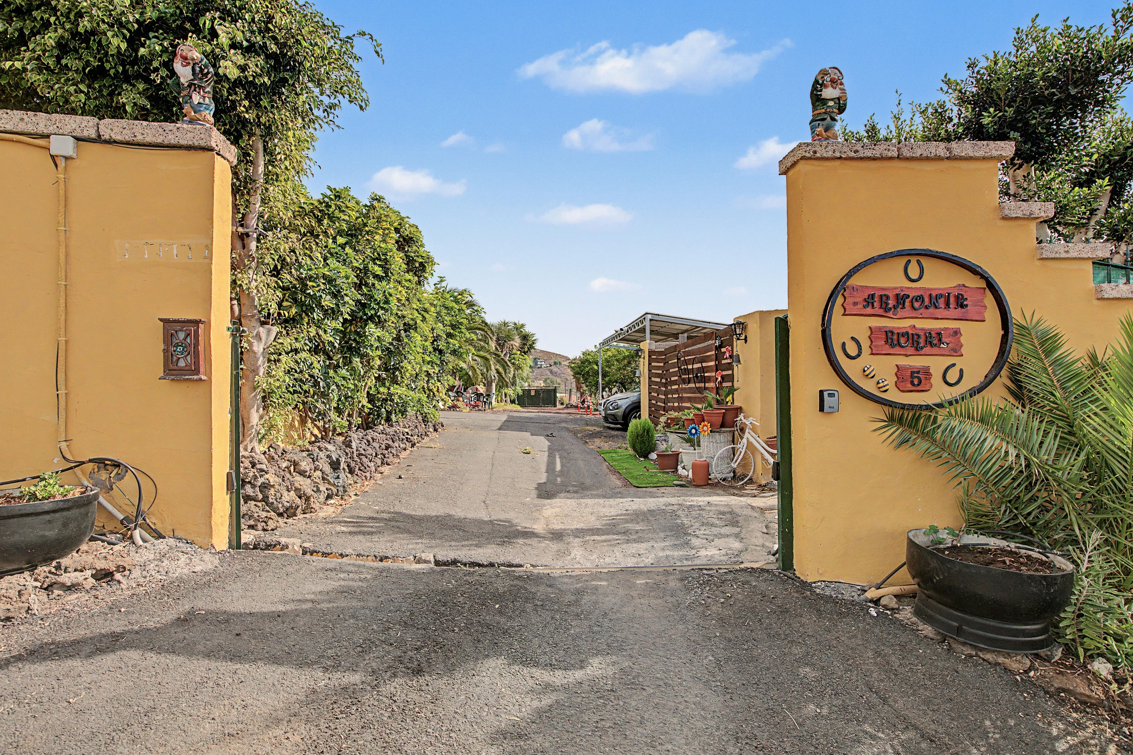Une entrée fermée par un portail, sur laquelle est apposée une plaque indiquant « ARMONIER RURAL ».