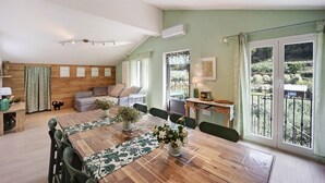A dining area with a wooden table, chairs, and a view of a balcony.