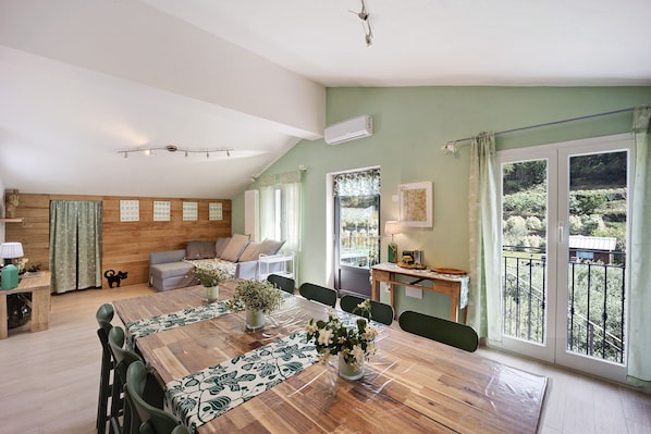 A dining area with a wooden table, chairs, and a view of a balcony.