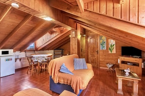 A wooden interior with a couch, table, and TV.