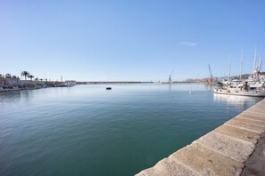 Un port de plaisance avec des bateaux amarrés, une eau calme et un ciel dégagé.