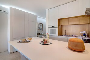 A modern kitchen with a white countertop, a microwave, and a sink. - "Apartamento Albufeira Prestige" with Pool, Wi-Fi & Garden (Albufeira)
