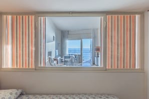 Una habitación con un ventanal grande, una cama y vista al mar.