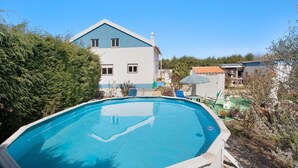 A swimming pool with a house in the background. - Apartment 'Quinta Das Andorinhas - Nazaré' with Mountain View, Private Pool and Wi-Fi (Casais Baixo)