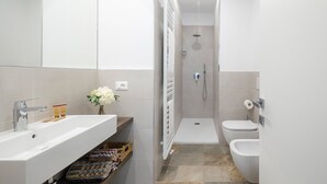 A modern bathroom with a shower, toilet, and sink.