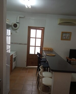 Una cocina con refrigerador, estufa y ventana con vistas.