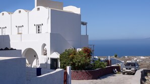 Un bâtiment blanc avec des portes en arc de cercle et une vue sur la mer.