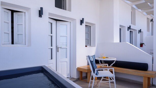 Un espace de vie extérieur moderne comprenant une piscine, un coin salon avec une table et des chaises, ainsi qu’un escalier menant à un niveau supérieur.