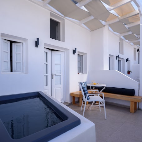 A modern outdoor living area with a pool, a seating area with a table and chairs, and a staircase leading to an upper level.