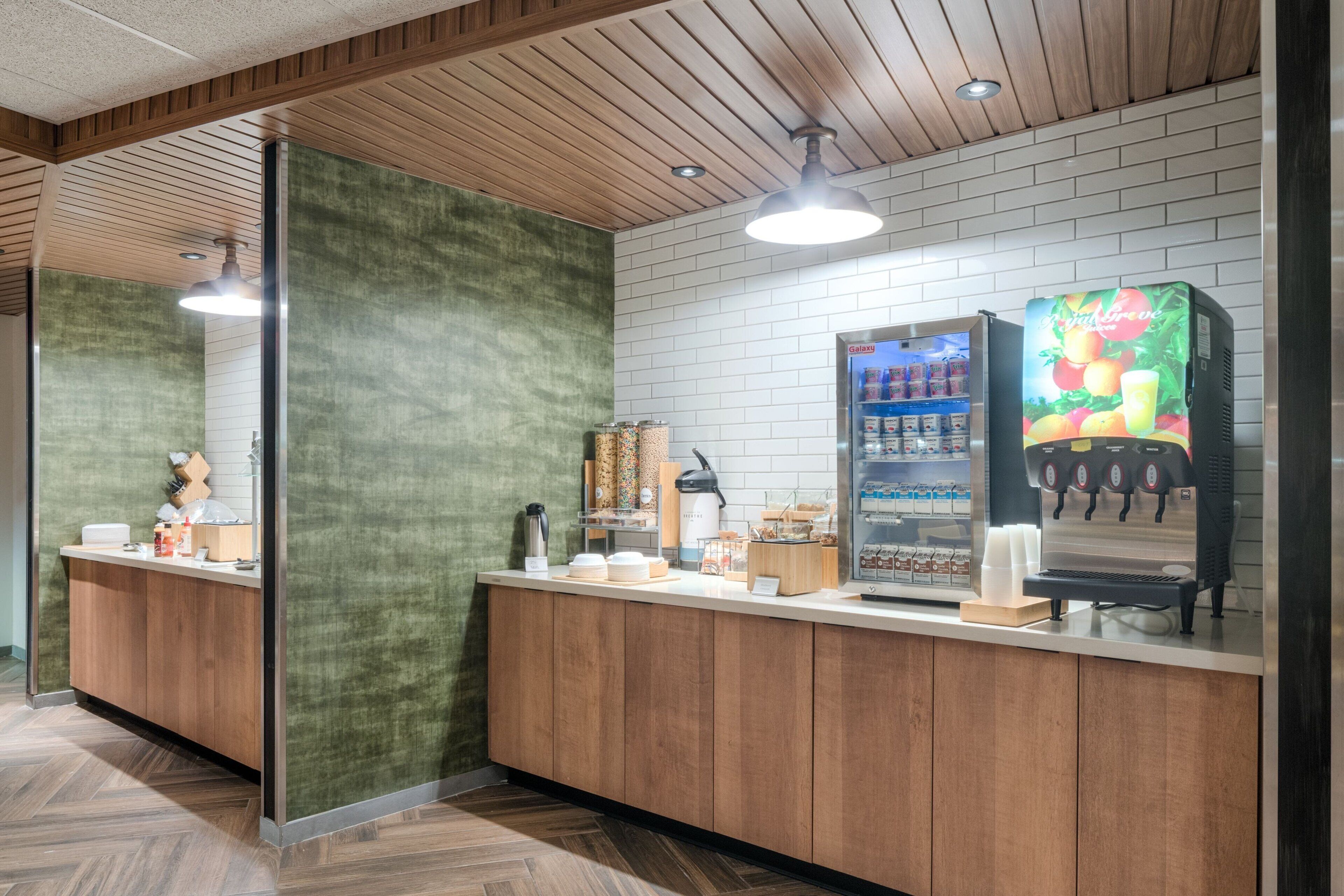Una zona de recepción con un mostrador de madera, un dispensador de bebidas y una máquina de café.