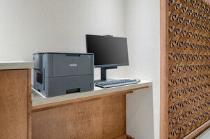 Un escritorio con una impresora Brother, un monitor y un teclado.