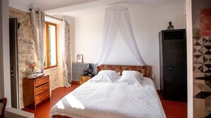 A bedroom with a bed, a nightstand, a dresser, a wardrobe, and a window with curtains. - "Olivier" Room – Quality B&B accommodation comes in all sizes (Fayence)