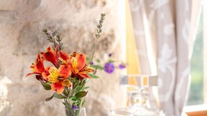 A tray with a vase of flowers, wine glasses, and a card on a wooden table. - "Olivier" Room – Quality B&B accommodation comes in all sizes (Fayence)