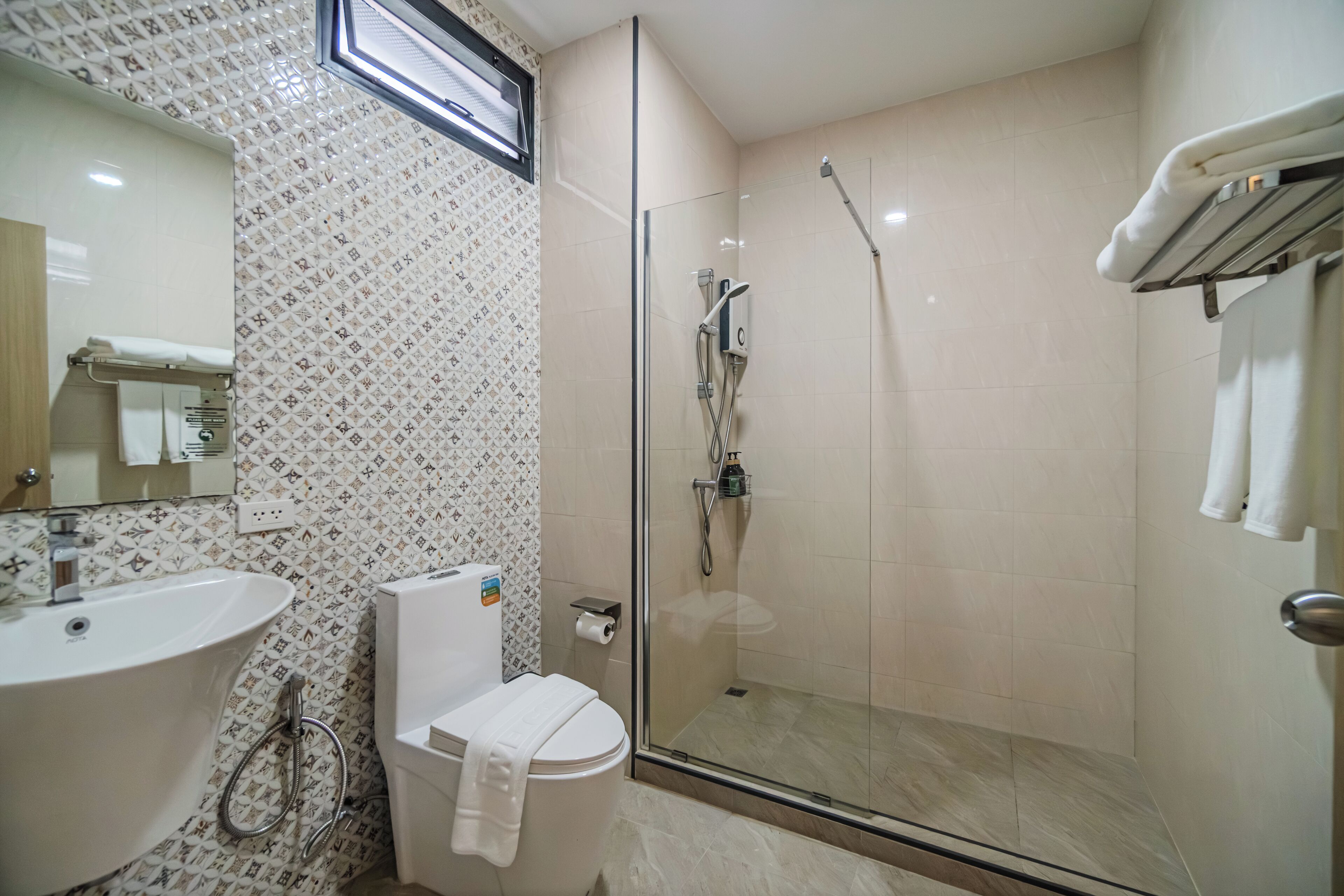 Une salle de bain moderne avec une douche à parois de verre, un lavabo et des toilettes.