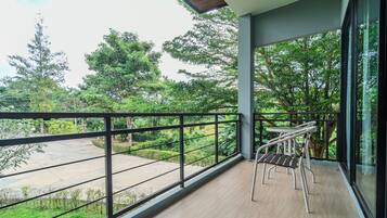 Un balcone con vista su un giardino e degli alberi.