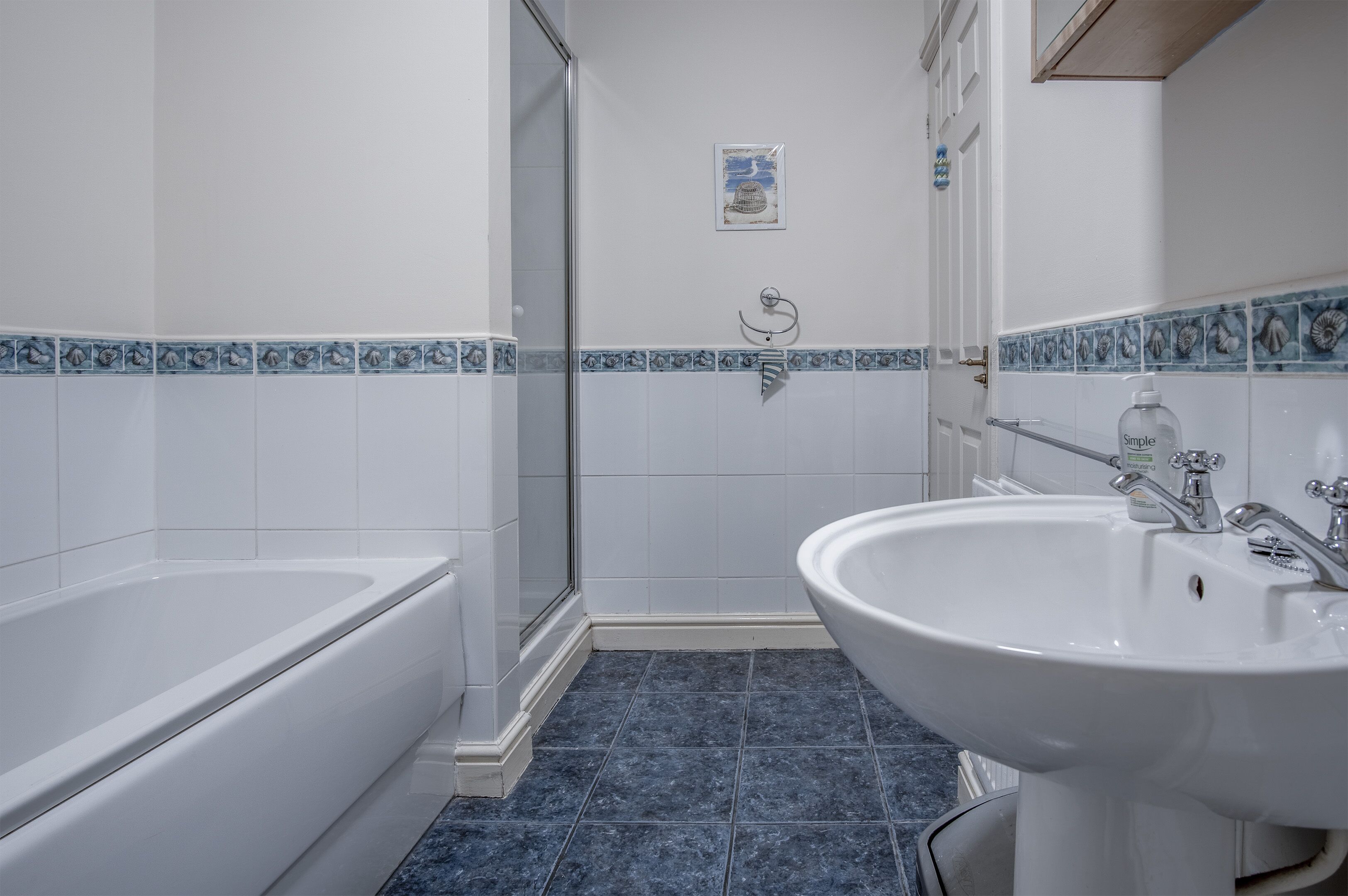 A bathroom with a bathtub, shower, and sink.