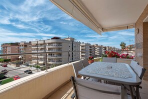 Enjoy the view from this balcony with a table and chairs, overlooking a residential area.