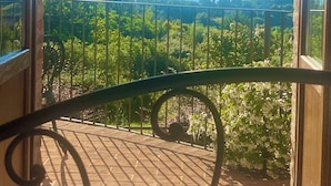 Un balcone con vista su un paesaggio montuoso e un cielo sereno.