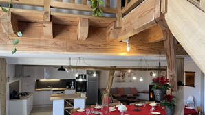 A dining area with a red tablecloth, wooden chairs, and hanging light fixtures. - Cozy rental in Blomard with shared pool and pet-friendly (Blomard)