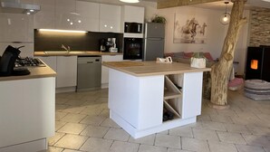 A modern kitchen with white cabinetry, a central island, a built-in oven, and a microwave. - Cozy rental in Blomard with shared pool and pet-friendly (Blomard)
