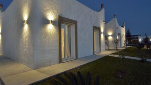 En modern byggnad med en unik arkitektonisk design, som består av en rad sammanlänkade rum med utomhusbelysning.