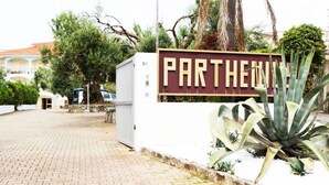 Un carrer pavimentat que condueix a un edifici amb un rètol que diu "PARTHENIUS".