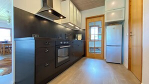 Una cocina moderna con horno empotrado, extractor de acero inoxidable y refrigerador.