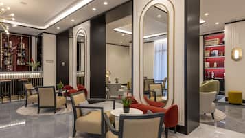 Eine moderne Hotelhalle mit Barbereich, Sitzgelegenheiten und einem großen Spiegel.