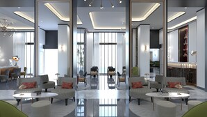 A modern hotel lobby with a central seating area, large windows, and a reflective floor. - H10 Palazzo Galla (Rome)