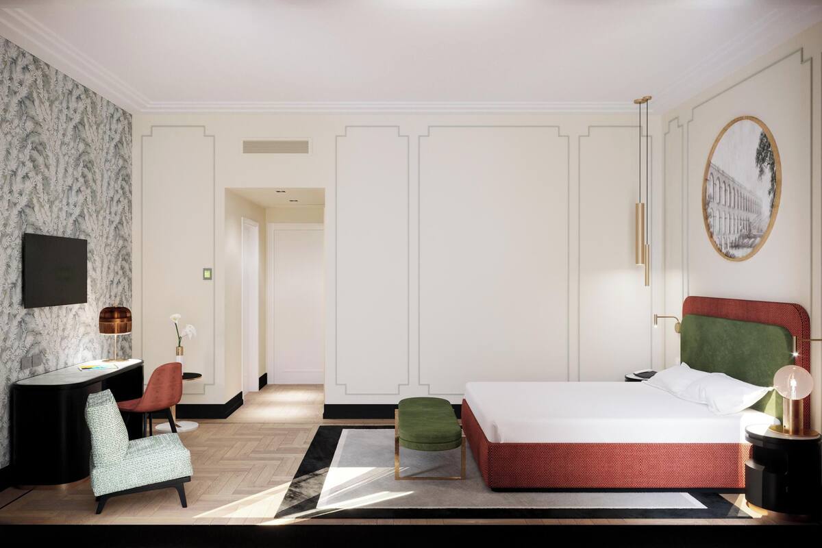 A modern bedroom with a bed, a desk, a chair, and a television.