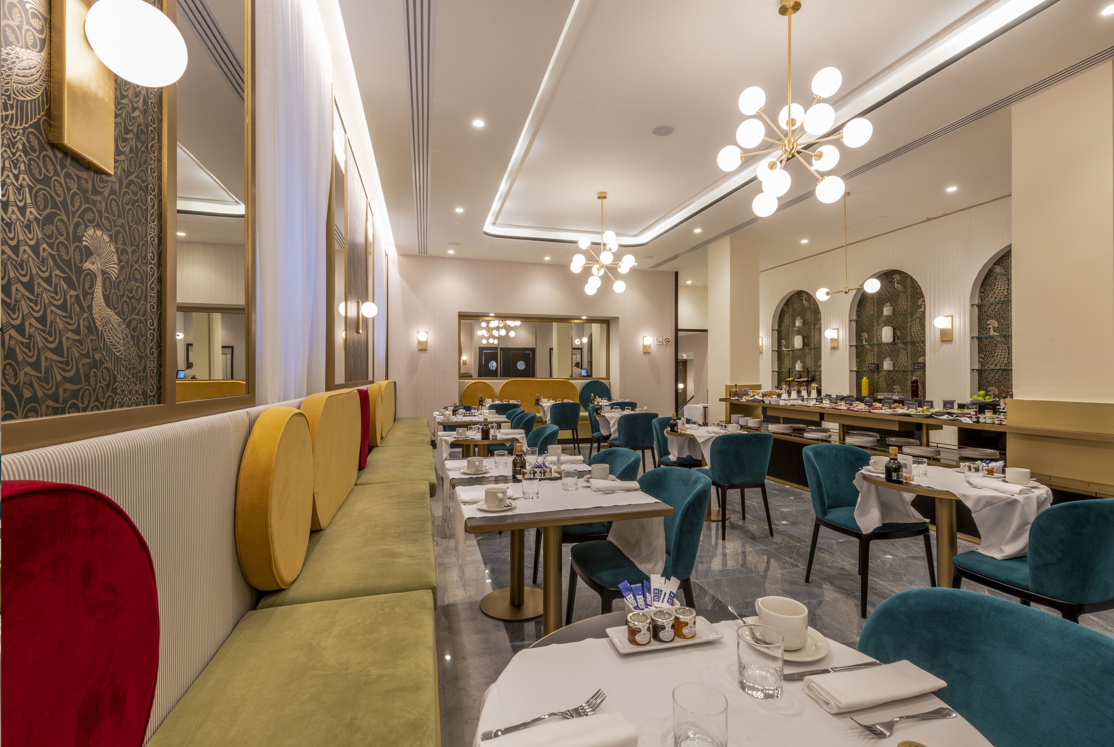 A restaurant with a long counter, multiple tables, and chairs.