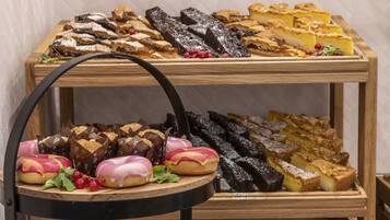 Una exhibición de diversos pasteles y postres sobre un soporte de madera.