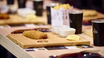 Una mesa de madera con un croissant, un gajo de limón y una taza de café.