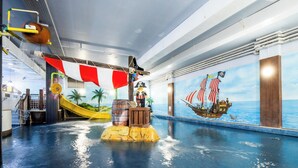 An indoor water play area with a pirate-themed mural, a slide, and a shipwreck play structure. - LEGOLAND Windsor Resort (Windsor)