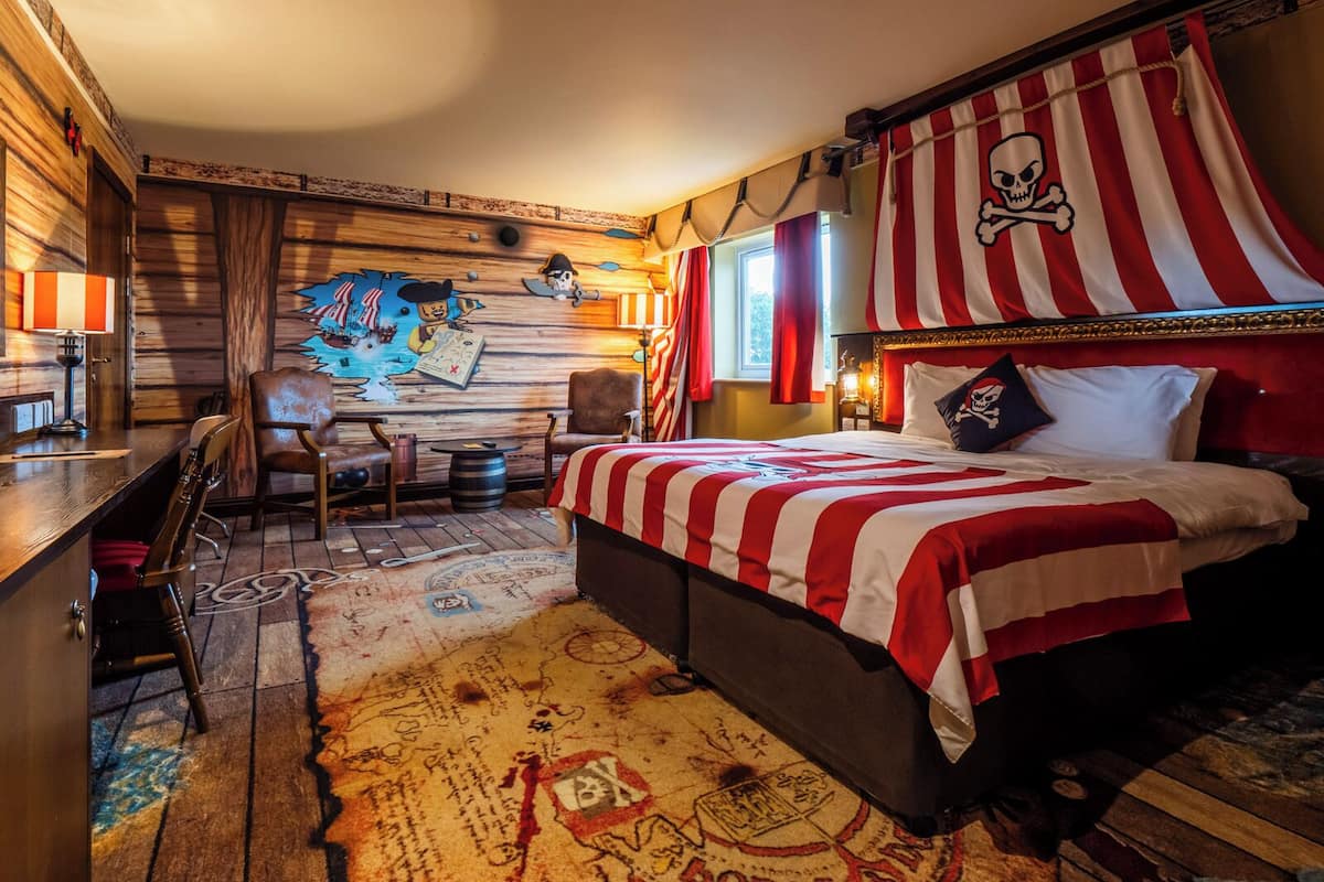 A pirate-themed room with a bed, a desk, and a chair.