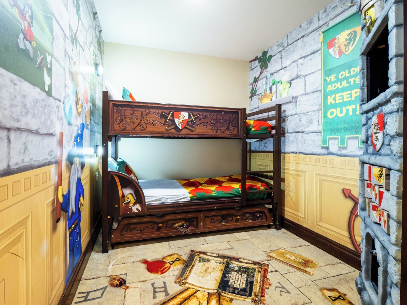 A bunk bed room with a mural, a banner, and a carpet with historical designs.