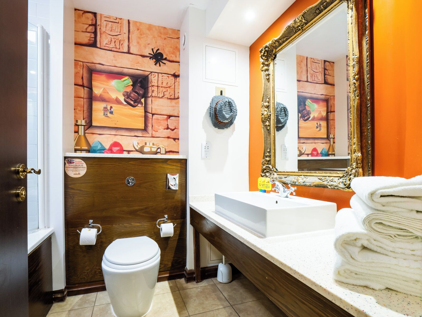 A bathroom with a wooden vanity, a large mirror, and a toilet.