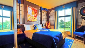 A hotel room with a large bed, a window with a view, a decorative wall piece, and a chair. - LEGOLAND Windsor Resort (Windsor)